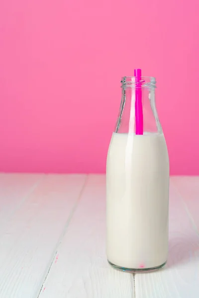 Bouteille de lait en verre sur fond rose — Photo