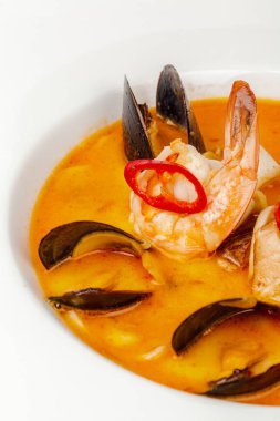 Kabuklu midyeler beyaz üzerine sosla pişirilir.