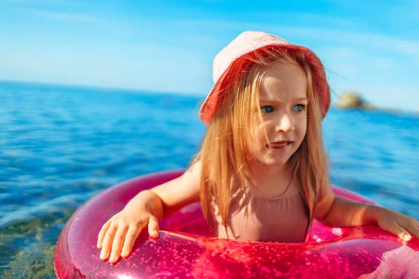 Bonne petite fille se baignant dans la mer avec cercle rose — Photo