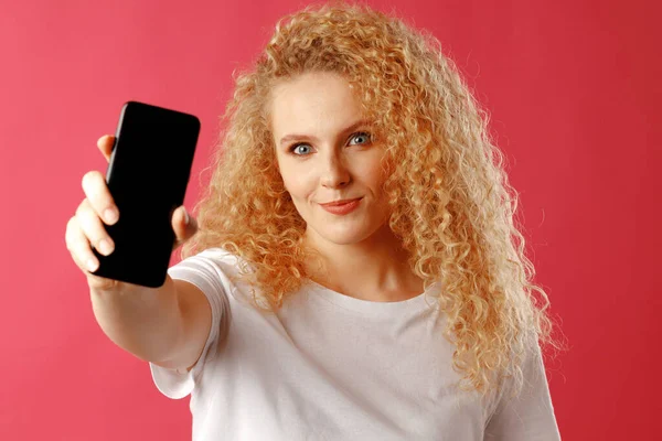 블랙 스마트폰 화면에 복사 공간이 있는 금발의 젊은 여성 — 스톡 사진
