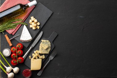 Gri arka planda şarap şişesi ve peynir çeşitleriyle kompozisyon