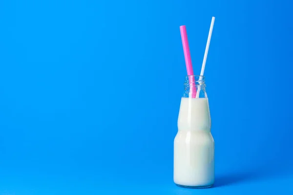 青を背景に新鮮な牛乳とガラス瓶 — ストック写真