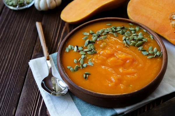 Creamy pumpkin soup on a wooden table — Stock Photo, Image
