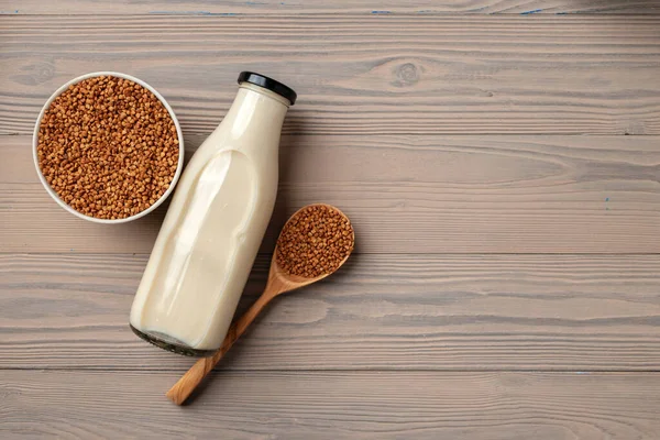 Concetto di latte di grano saraceno con bottiglia di latte e grano saraceno in ciotola — Foto Stock