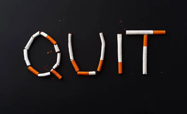 Palabra de inscripción QUIT hecha de cigarrillos vista superior — Foto de Stock