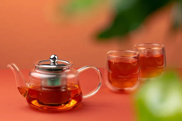 Стеклянный чайник и две чашки чая — стоковое фото