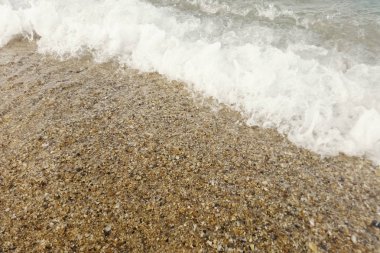 Kumlu sahilde mavi okyanus dalgası Yaz Arkaplanı 'nı kapatır