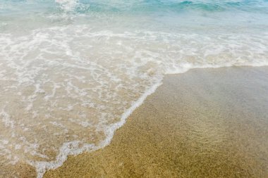 Kumlu sahilde mavi okyanus dalgası Yaz Arkaplanı 'nı kapatır