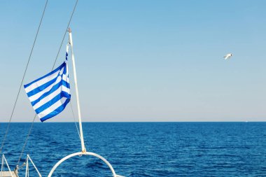 Bir teknenin arkasında dalgalanan Yunan bayrağı