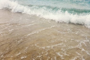 Kumlu sahilde mavi okyanus dalgası Yaz Arkaplanı 'nı kapatır