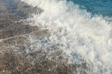 Sahildeki mavi okyanus dalgası yaz arkaplanını kapatıyor.