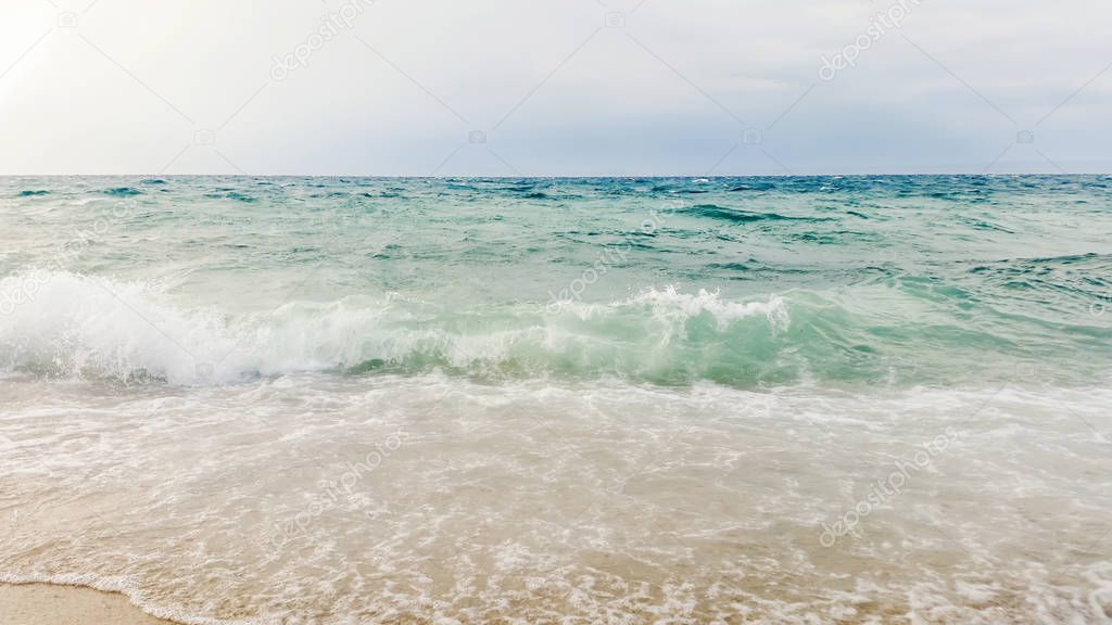 Tropical seascape waves crash over the beach. Sky and sea