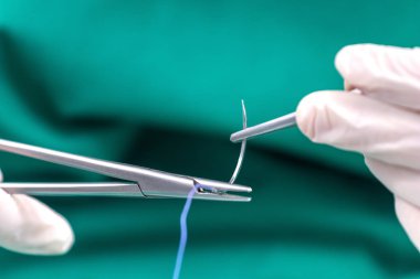 Cerrahi tutan Doktor forseps iğne, malzeme dikiş dikerim.