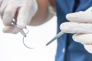 Cerrahi tutan Doktor forseps iğne, malzeme dikiş dikerim.