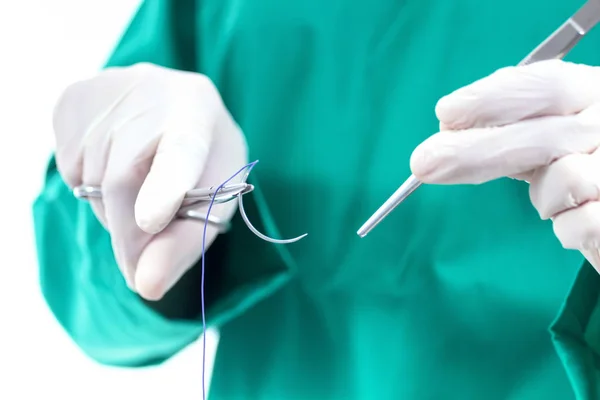 Cerrahi tutan Doktor forseps iğne, malzeme dikiş dikerim.