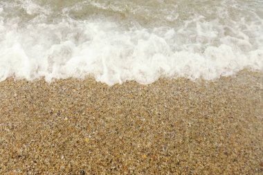 Sahildeki mavi okyanus dalgası yaz arkaplanını kapatıyor.