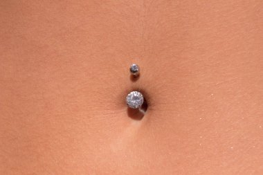 Belly piercing in the navel close up clipart