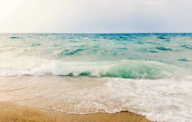 Tropik deniz manzarası dalgaları sahile çarpar. Gökyüzü ve deniz