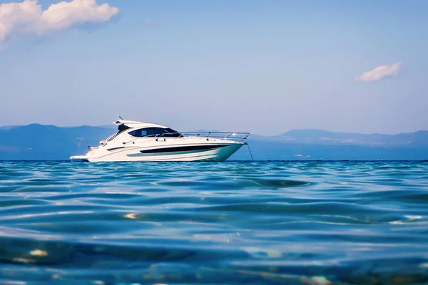 Bateau à moteur flottant sur l'eau turquoise claire — Photo