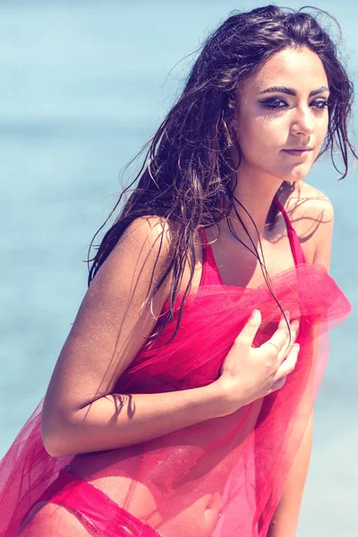 Fashion portrait of a young girl in a red dress on the beach. Su — Stock Photo, Image
