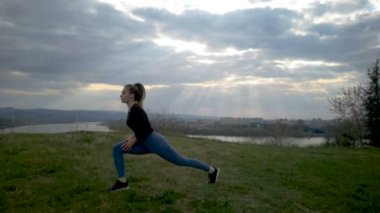 Ağır çekim genç kadın Park siluet egzersiz. Genç kadının eğitim egzersiz ağır çekim yapması uygun. Çalışan bir egzersiz yaptıktan sonra parkta uzanan genç mutlu bir kadın. Egzersiz açık kavramı.