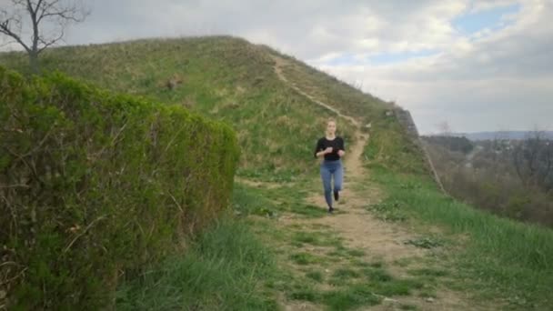 Una Joven Corriendo Por Una Colina Cubierta Hierba Correr Cámara — Vídeos de Stock