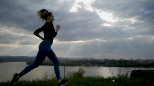 慢动作年轻妇女跑在日落 年轻妇女跑剪影 慢动作慢 美丽的云 运动的女人工作户外 — 图库视频影像