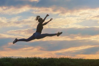 Sportif genç kadın, Açık sabah bulutlar arka plan, atlama
