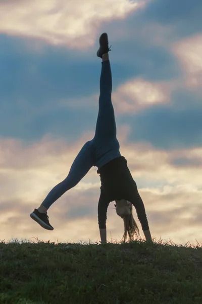 Jovem mulher fazendo cartwheel na grama Manhã treino beautif — Fotografia de Stock