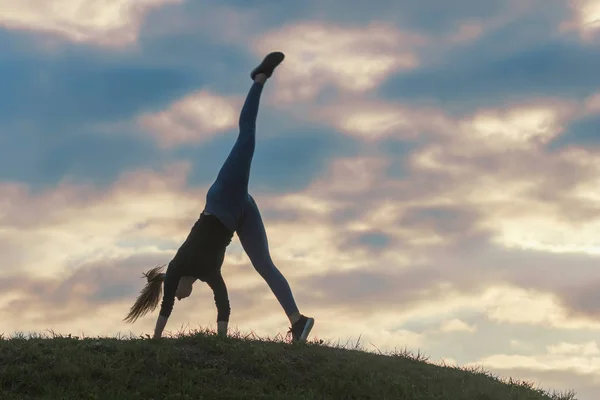 Jovem mulher fazendo cartwheel na grama Manhã treino beautif — Fotografia de Stock