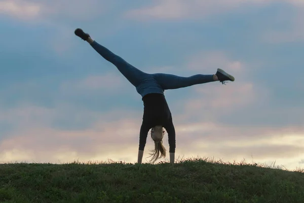 Jovem mulher fazendo cartwheel na grama Manhã treino beautif — Fotografia de Stock