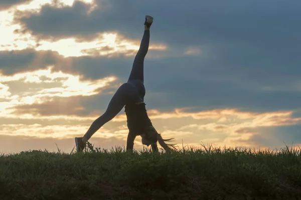 Jovem mulher fazendo cartwheel na grama Manhã treino beautif — Fotografia de Stock