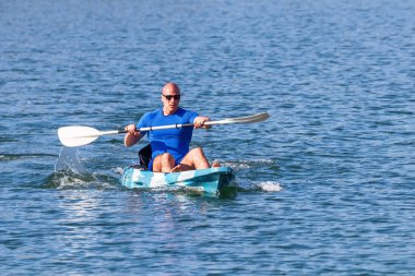 Genç kano kürek çeken kano. Sporcu, Blue Water 'da kayak yapıyor..