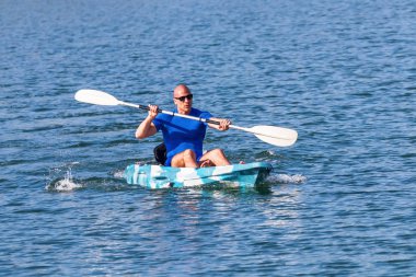 Genç kano kürek çeken kano. Sporcu, Blue Water 'da kayak yapıyor..