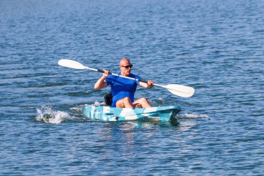 Genç kano kürek çeken kano. Sporcu, Blue Water 'da kayak yapıyor..