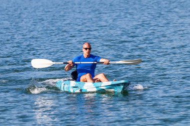 Genç kano kürek çeken kano. Sporcu, Blue Water 'da kayak yapıyor..