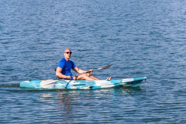 Genç kano kürek çeken kano. Sporcu, Blue Water 'da kayak yapıyor..