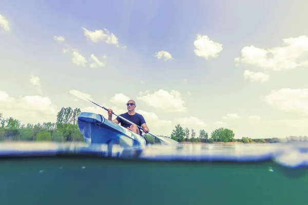 Młody człowiek kajakarstwo na jeziorze, kajakarstwo pod wodą, Split Shot — Zdjęcie stockowe