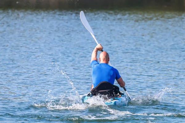 Young Kayaker Paddling Kayak. Sportsman kayaking Blue Water.