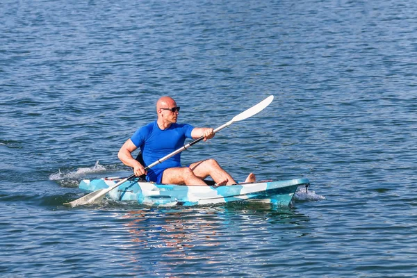 A fiatal kajakozó kajak. Sportriporter kajakozik Kék Víz. — Stock Fotó