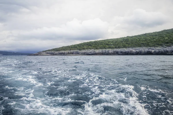 Wake of boat and shoreline, Cloudy Sky