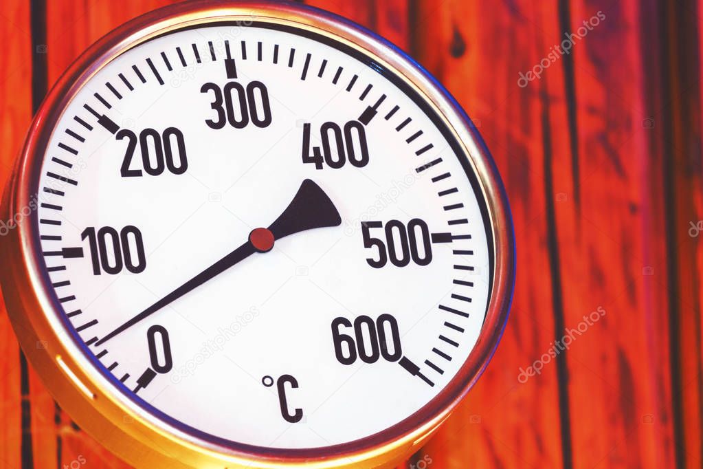 Oven thermometer close up, retro look thermometer wooden backgro