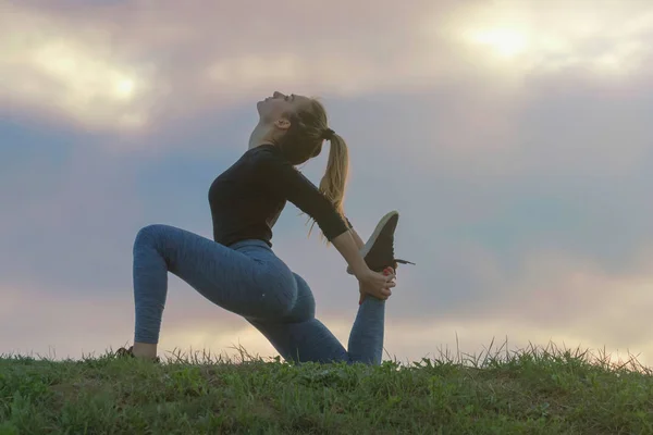 Mujer joven y atractiva practicando yoga, ejercitando, al aire libre Mor — Foto de Stock