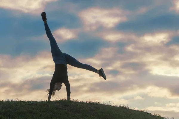 Jovem mulher fazendo cartwheel na grama Manhã treino beautif — Fotografia de Stock