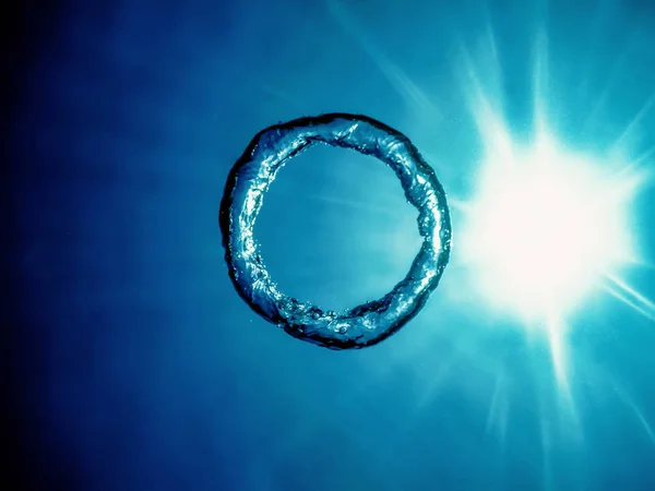 Bubble ring Underwater ascends towards the sun. — Stock Photo, Image