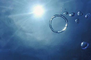 Bubble Ring Underwater ascends towards the Sun. clipart