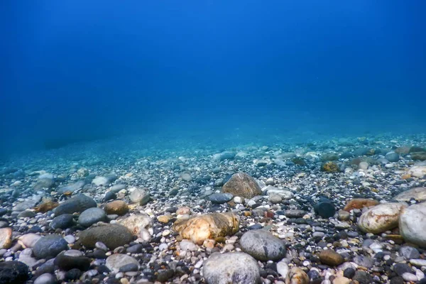 Подводные скалы и галька на морском дне — стоковое фото