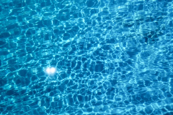 Acqua della piscina. Acqua increspata. Sole Riflessione sfondo. — Foto Stock