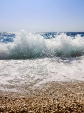 Çakıl taşları plajındaki Mavi Okyanus Dalgası Yaz Arkaplanı