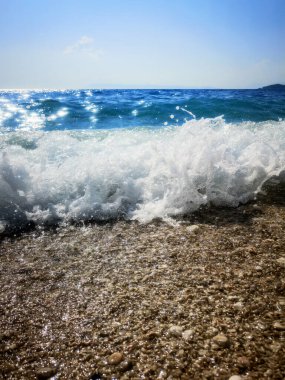 Çakıl taşları plajındaki Mavi Okyanus Dalgası Yaz Arkaplanı